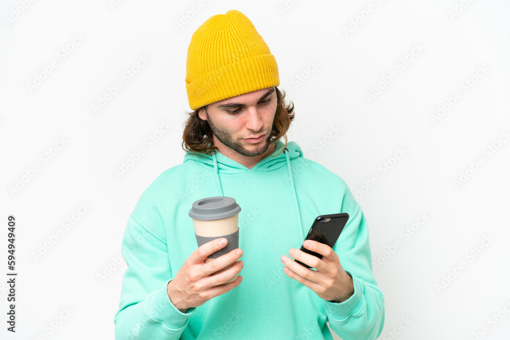 Young handsome man isolated on white chroma background holding coffee to take away and a mobile Young handsome man isolated on white chroma background holding coffee to take away and a mobile