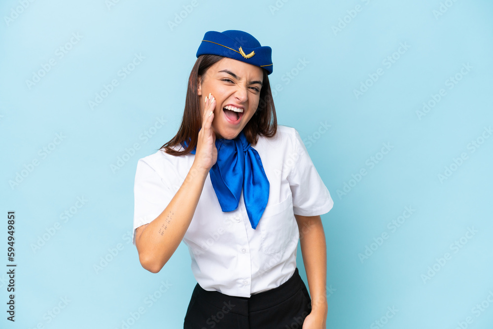 Airplane stewardess caucasian woman isolated on blue background shouting with mouth wide open Airplane stewardess caucasian woman isolated on blue background shouting with mouth wide open