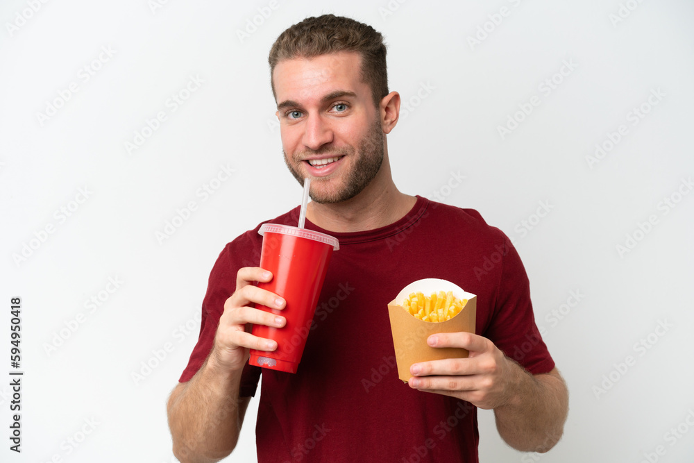 Young caucasian man holding a burger and potatoes isolated on white background Young caucasian man holding a burger and potatoes isolated on white background