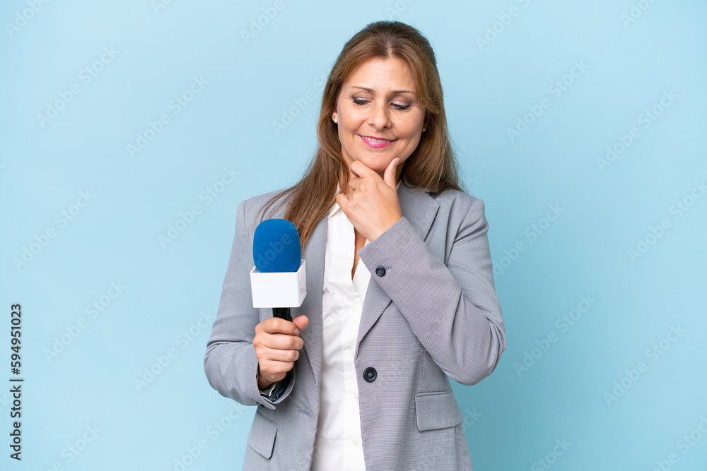Middle-aged TV presenter woman over isolated blue background looking to the side and smiling Middle-aged TV presenter woman over isolated blue background looking to the side and smiling