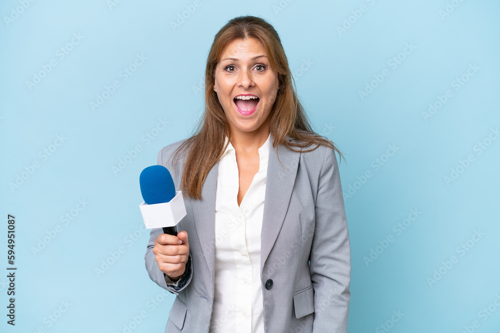 Middle-aged TV presenter woman over isolated blue background with surprise facial expression Middle-aged TV presenter woman over isolated blue background with surprise facial expression