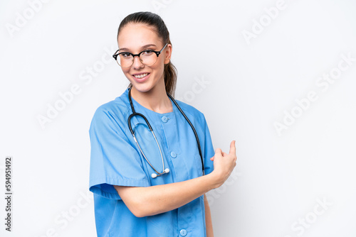 Young caucasian surgeon doctor woman isolated on white background pointing back © luismolinero