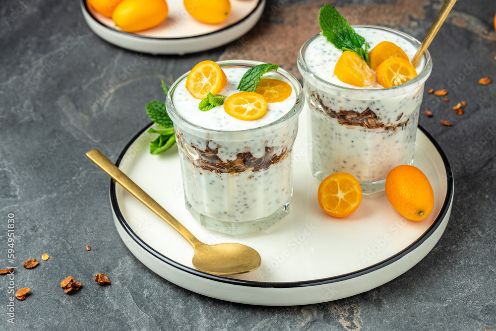Kumquat chia pudding yogurt on a light background. healthy breakfast. banner, menu, recipe place for text, top view Kumquat chia pudding yogurt on a light background. healthy breakfast. banner, menu, recipe place for text, top view