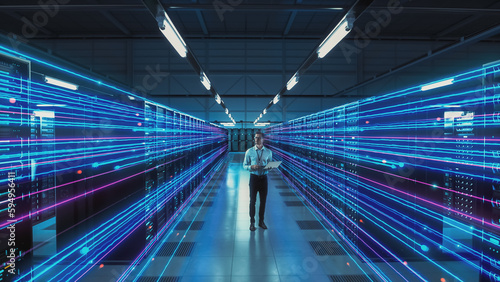 Futuristic Concept: Data Center Chief Technology Officer Using Laptop, Standing In Warehouse, Information Digitalization Lines Streaming Through Servers. SAAS, Cloud Storage, Online Service