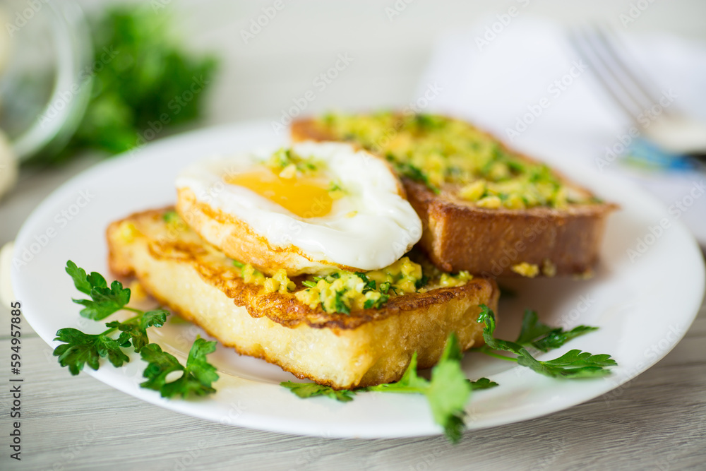 Fried croutons in batter with garlic and herbs and a fried egg in a plate. Fried croutons in batter with garlic and herbs and a fried egg in a plate.