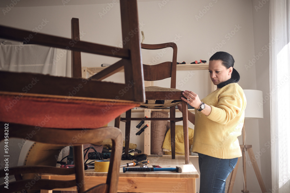 Woman working in a small home workshop for furniture repairing and restoration. Woman working in a small home workshop for furniture repairing and restoration.