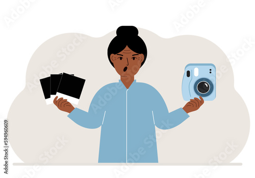 A woman holds a camera in one hand and frames in the other.