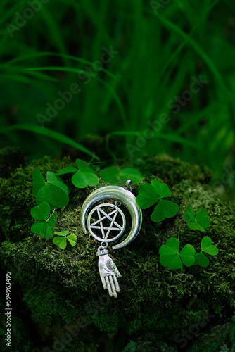 amulet with pentagram on abstract natural dark forest background. spiritual ritual. witchcraft, pagan traditions, wiccan practice. esoteric symbol of pentacle and hand. copy space