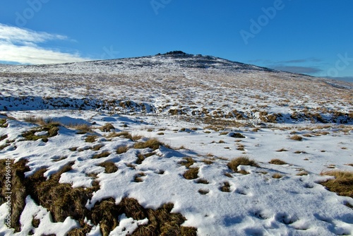 Picturesque winter scene featuring a snow-covered hill in Dartmoor National Park, UK