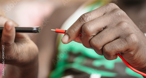 Close-up of hand inserting USB charger into mobile phone