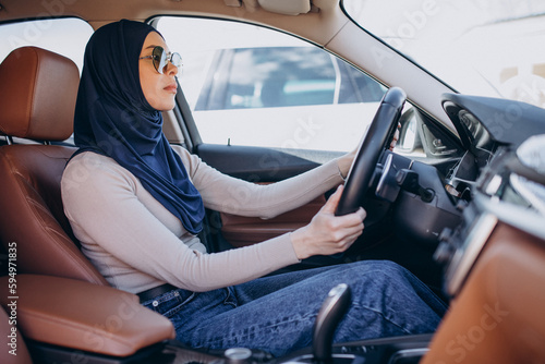 Young muslim woman sitting in her car and looking into the mirror © Petro