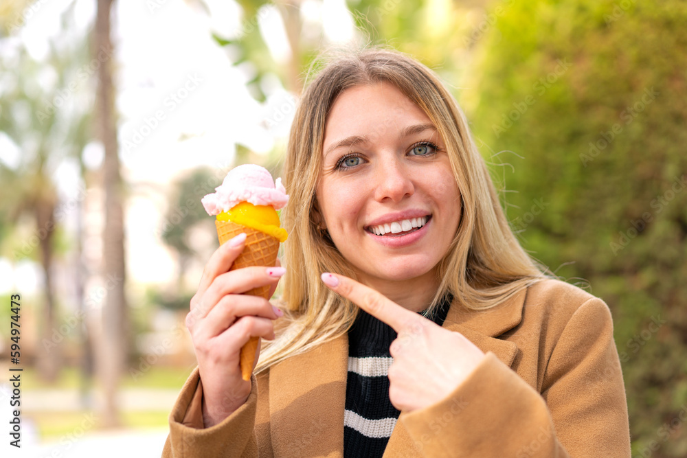 Young pretty blonde woman with a cornet ice cream at outdoors Young pretty blonde woman with a cornet ice cream at outdoors