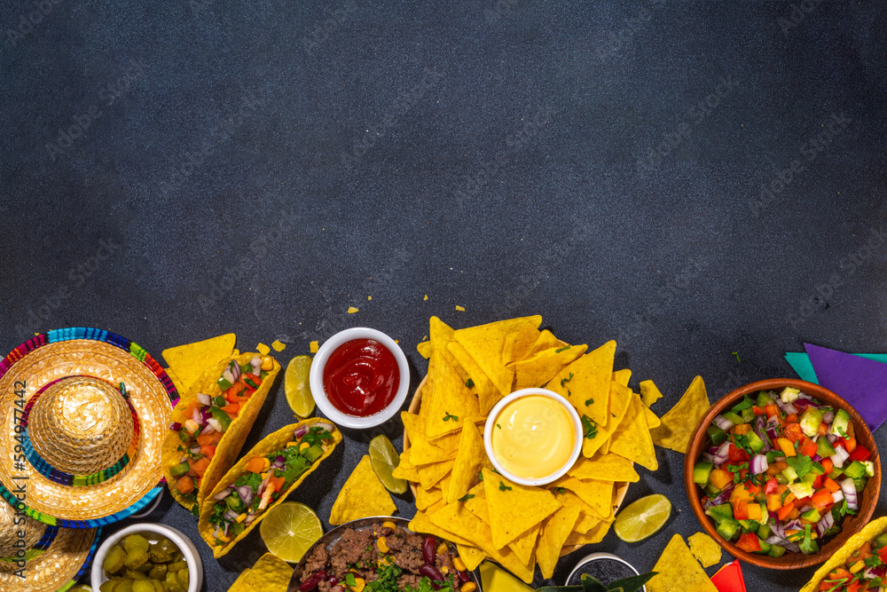 Cinco de mayo party food. Mexican holiday Cinco de mayo traditional dishes, snacks, tortilla corn chips, nachos, tacos, salsa, sauces. Friends and family feast background top view copy space Cinco de mayo party food. Mexican holiday Cinco de mayo traditional dishes, snacks, tortilla corn chips, nachos, tacos, salsa, sauces. Friends and family feast background top view copy space