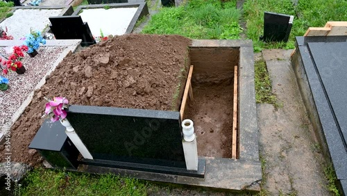 A freshly dug grave in the cemetery. Funeral preparation. Open grave.
