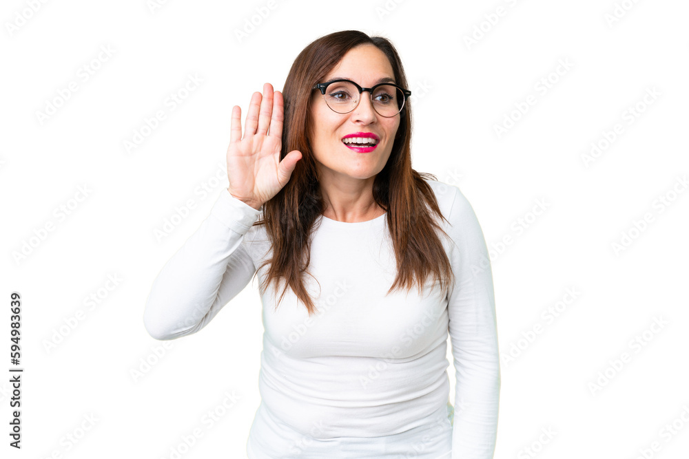 Middle age woman over isolated chroma key background listening to something by putting hand on the ear Middle age woman over isolated chroma key background listening to something by putting hand on the ear
