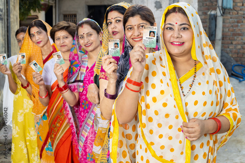 Photos Group of happy traditional indian women standing in queue showing voter card id to cast vote at polling station
