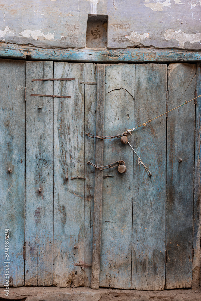 Blue door with locks, chains & a swastika about