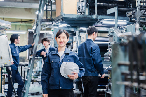 ヘルメットを持つ女性作業員