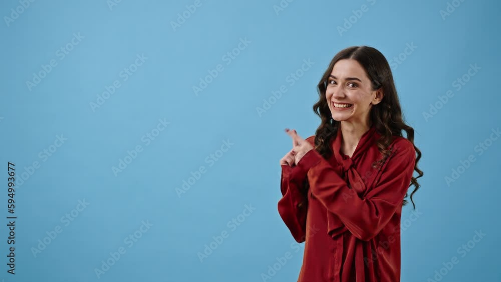 Beautiful woman looks upward pointing with index fingers Beautiful woman looks upward pointing with index fingers