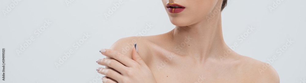 cropped view young woman with red lips touching bare shoulder isolated on grey, banner. cropped view young woman with red lips touching bare shoulder isolated on grey, banner.