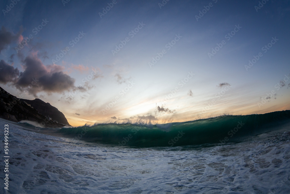 Obraz premium huge wave crashing in the ocean at sunset
