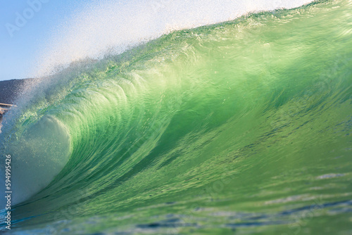 perfect green wave breaking on the beach