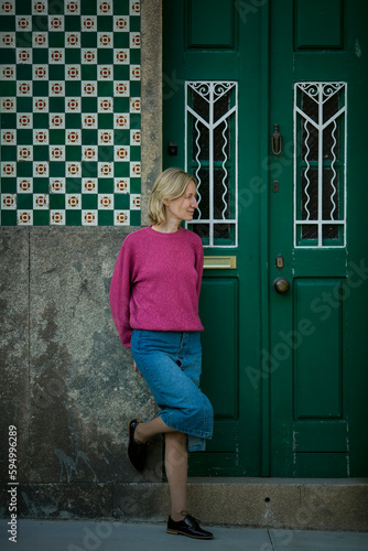 A woman stands at the entrance to a traditional Portuguese house.