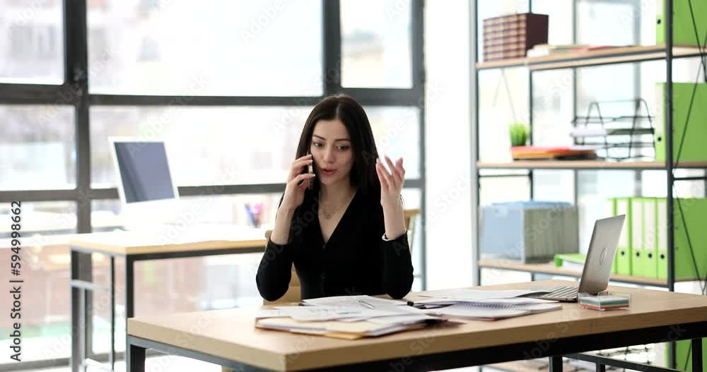 A beautiful business woman speaks by phone in the office, a close-up. Telephone negotiations A beautiful business woman speaks by phone in the office, a close-up. Telephone negotiations