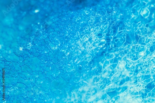 Closeup of blue translucent soap bubbles floating on the water surface, perfect for backgrounds