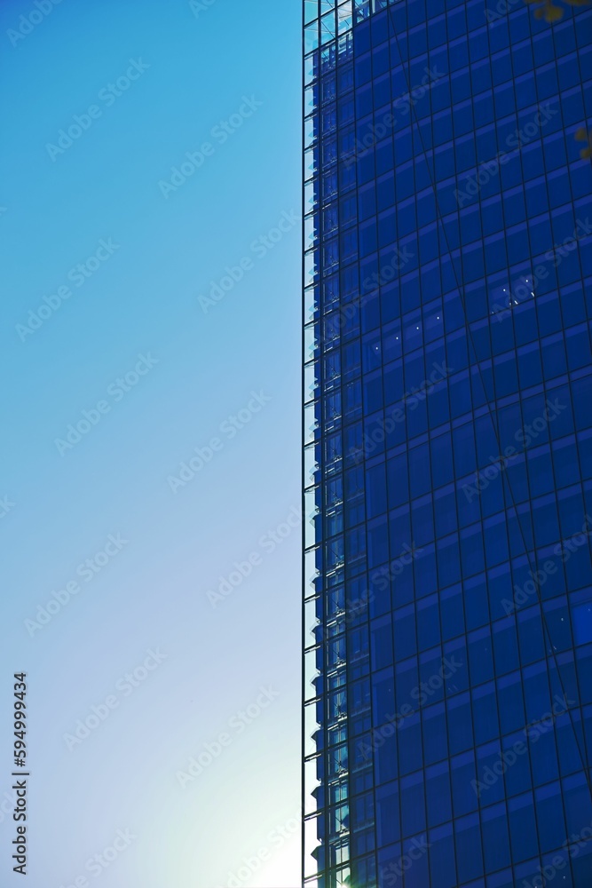 Modern glass and steel skyscraper against a blue sky