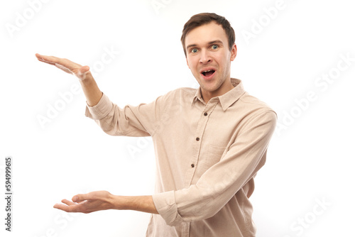 Portrait of funny brunet caucasian young male showing size with hands or holding something isolated on white studio background