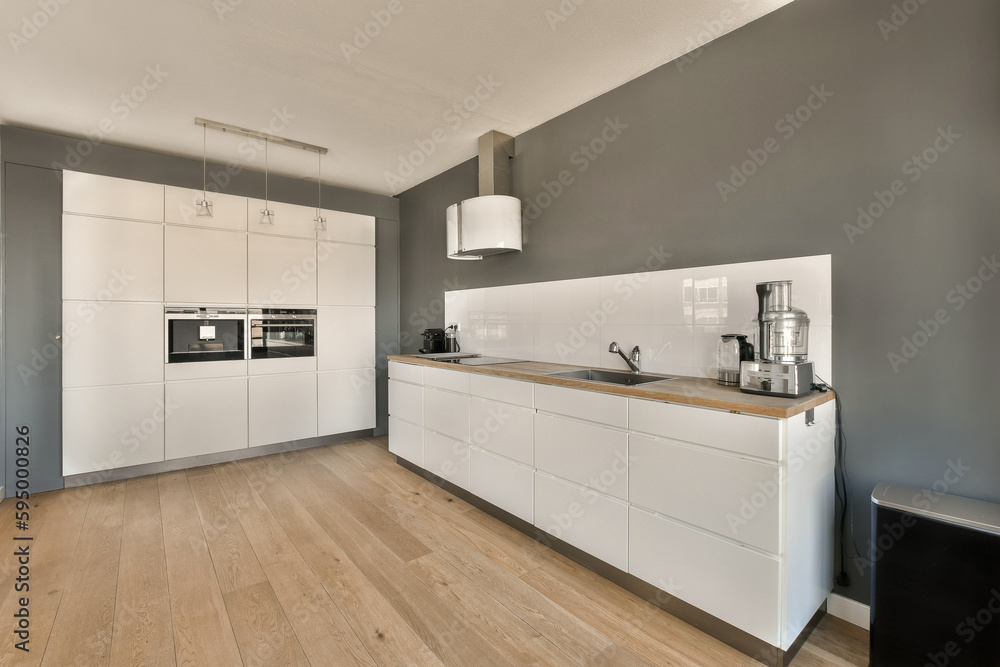 Fototapeta premium a kitchen with wood flooring and white cabinetd cupboards on the wall behind it is an oven, microwave and dishwasher
