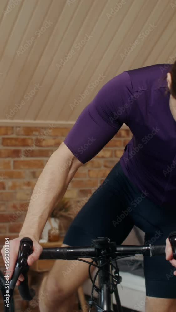 A man starts a bike workout at a home bike station in a stylish modern bedroom interior. Removing a bike into an indoor cardio exercise bike A man starts a bike workout at a home bike station in a stylish modern bedroom interior. Removing a bike into an indoor cardio exercise bike
