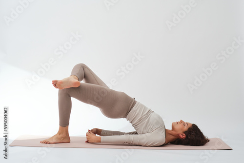 Flexible female practicing bridge pose during yoga