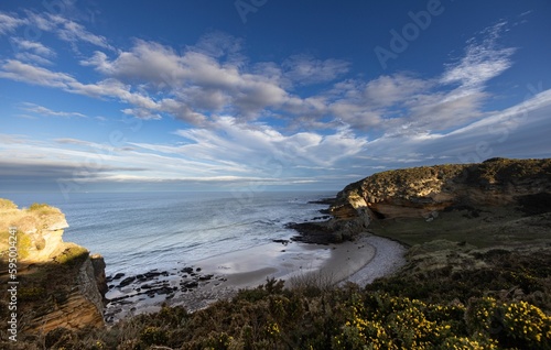 Expansive coastal landscape featuring a rocky shoreline adjacent to cliffs in the United Kingdom