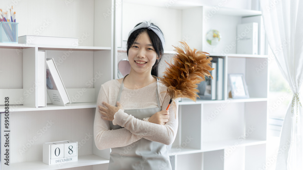 Housewife holding a dusting brush to clean things Pillows, rugs and other things in the living room, Big cleaning,Removes germs and dirt and deep stains, Clean up on weekends. Housewife holding a dusting brush to clean things Pillows, rugs and other things in the living room, Big cleaning,Removes germs and dirt and deep stains, Clean up on weekends.