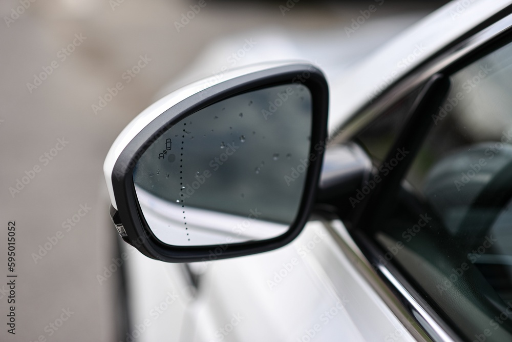 Side view mirror of a vehicle with water droplets on its glass surface Side view mirror of a vehicle with water droplets on its glass surface