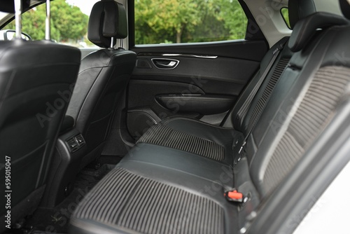 Close-up image of black leather passenger seats in an automobile interior © Stefan Radosavljevic/Wirestock Creators