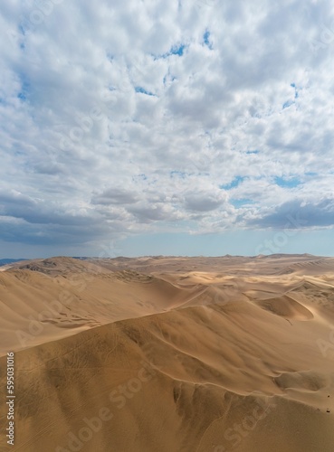 Fototapeta Naklejka Na Ścianę i Meble -  Beautiful view of sand dunes in the desert against a backdrop of a blue sky with white clouds