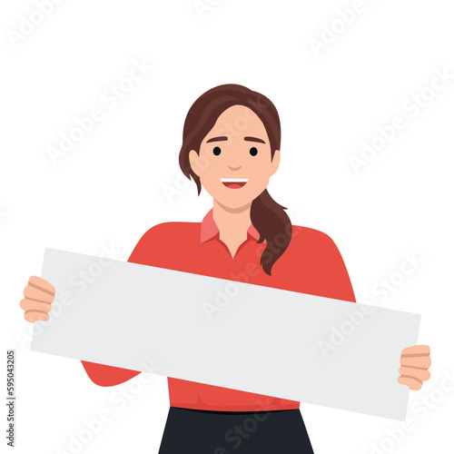 Positive woman holding blank white placard smiling and looking at camera demonstrating banner with copy space. Young girl teenager shows blank banner for presentation of promotional product