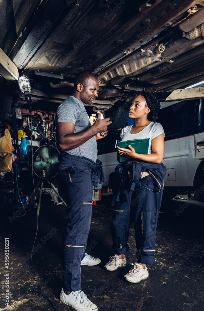 Professional Car Mechanic is Investigating Under a Vehicle on a Lift in Service. Auto Service Worker Checking Car Under Carriage Look For Issues. Car service technician check and repair customer car. Professional Car Mechanic is Investigating Under a Vehicle on a Lift in Service. Auto Service Worker Checking Car Under Carriage Look For Issues. Car service technician check and repair customer car.