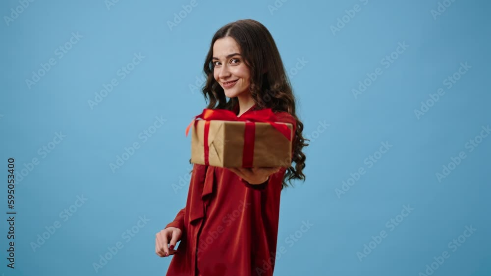 Woman holds gift box with red bow offering to take package Woman holds gift box with red bow offering to take package