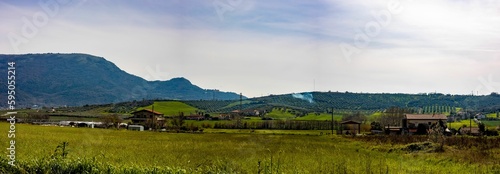 Panoramic shot of a valley surrounded by mountains under the sunlight in the countryside
