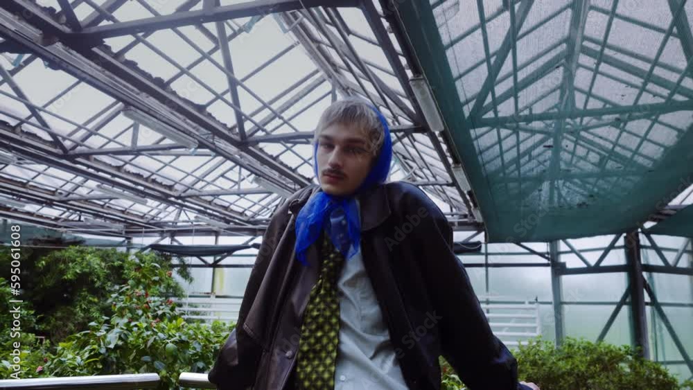 Captivating and confident, the androgynous lad in a stylish scarf poses among verdant foliage, locking eyes with the lens. Captivating and confident, the androgynous lad in a stylish scarf poses among verdant foliage, locking eyes with the lens.