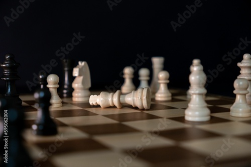 A dramatic depiction of the fallen white king chess piece on a chessboard