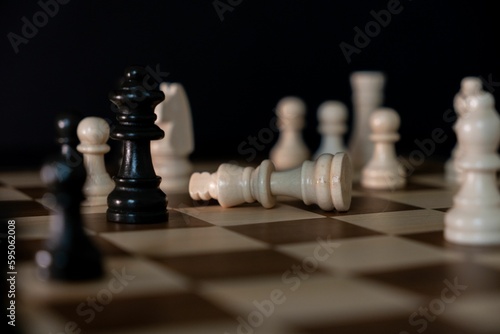 Fotografie A dramatic depiction of the fallen white king chess piece on a chessboard