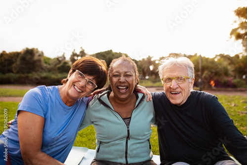 Happy multiracial senior friends having fun smiling at the camera after training activities in the park