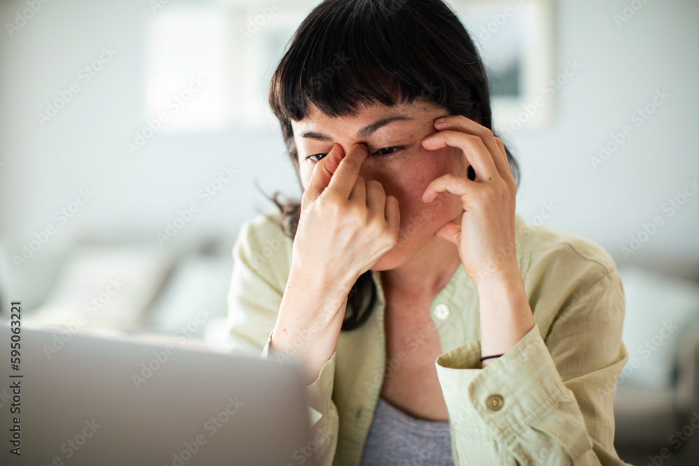 Young Japanese Woman working on a laptop in the kitchen