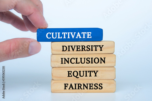 Hand holding blue wooden block with text - cultivate diversity, inclusion, equity and fairness. Respecting diversity concept photo