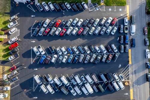 View of a parking lot filled with a variety of  cars and  trucks